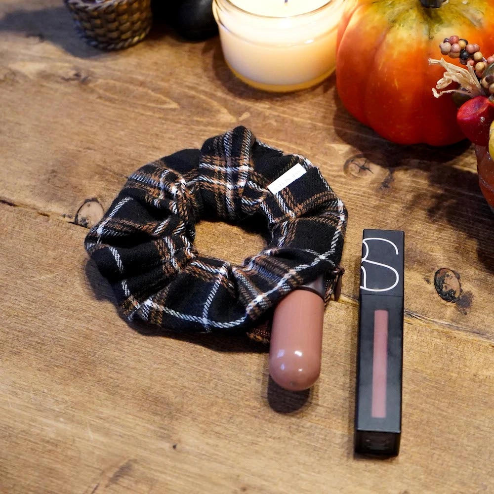 Brown and cream plaid flannel scrunchie with hidden zipper pocket for valuables (cash, keys, AirPods), featuring strong elastic for a secure hold, inspired by Halloween and the fall season, perfect for workouts and festivals.
