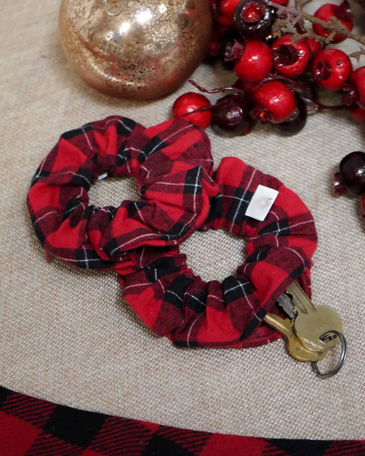 Red flannel holiday scrunchie with a hidden zipper pocket for valuables (cash, keys, AirPods), featuring strong elastic for a secure hold. Inspired by the Christmas season, perfect for workouts, festivals, and holiday events.