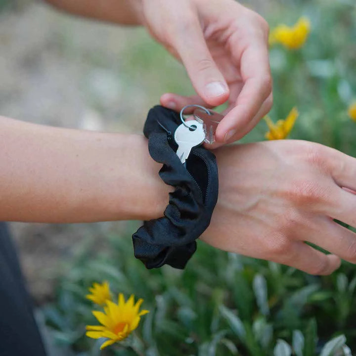 Satin black hair scrunchie ponytail holder featuring a hidden zipper pocket for storing valuables (cash, keys, AirPods) and strong elastic for a secure hold. Ideal for workouts, festivals, gifts, and holiday stocking stuffers.