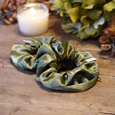 Satin green fall scrunchie with a hidden zipper pocket for valuables (cash, keys, AirPods), featuring strong elastic for a secure hold, inspired by the fall season, perfect for workouts and festivals.