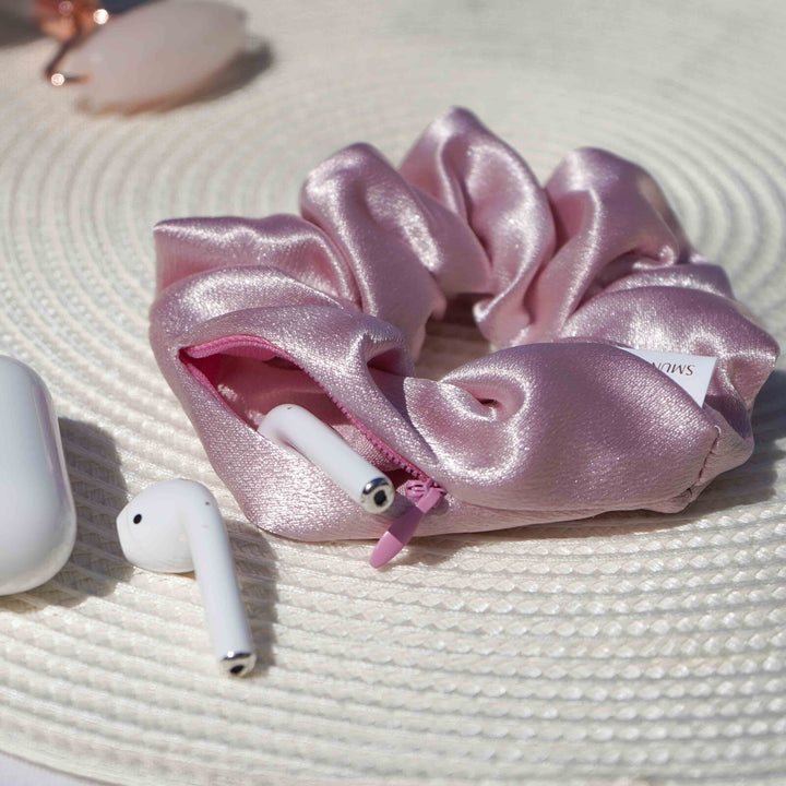 Satin light pink hair scrunchie ponytail holder featuring a hidden zipper pocket for storing valuables (cash, keys, AirPods) and strong elastic for a secure hold. Ideal for workouts, festivals, gifts, and holiday stocking stuffers.