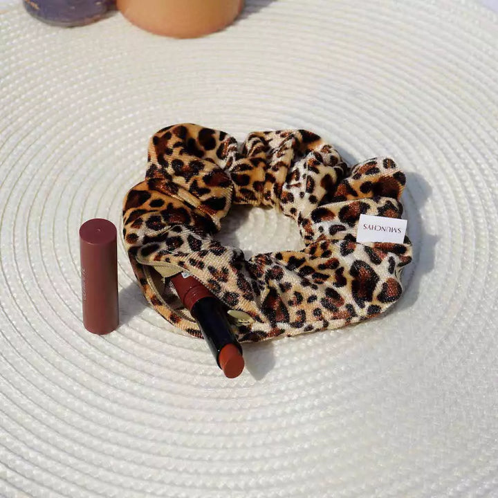 Velvet cream and beige leopard print hair scrunchie ponytail holder featuring a hidden zipper pocket for storing valuables (cash, keys, AirPods) and strong elastic for a secure hold. Ideal for workouts, festivals, gifts, and holiday stocking stuffers.