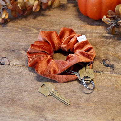 Velvet orange fall scrunchie with hidden zipper pocket for valuables (cash, keys, AirPods), strong elastic for secure hold, inspired by Halloween and fall season, perfect for workouts and festivals.