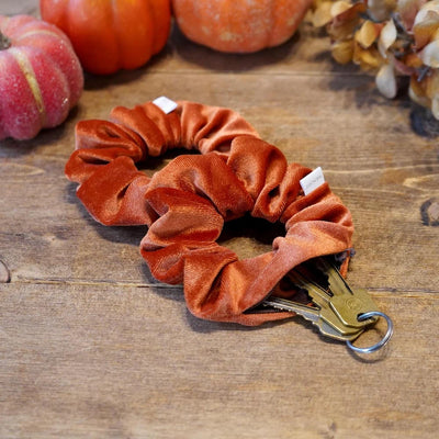 Velvet orange fall scrunchie with hidden zipper pocket for valuables (cash, keys, AirPods), strong elastic for secure hold, inspired by Halloween and fall season, perfect for workouts and festivals.